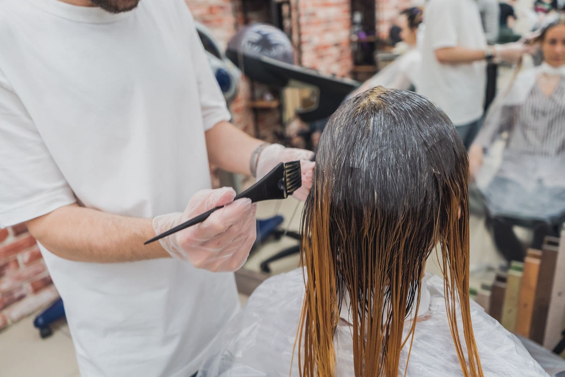 Hair colourist applying colour with a brush in a salon