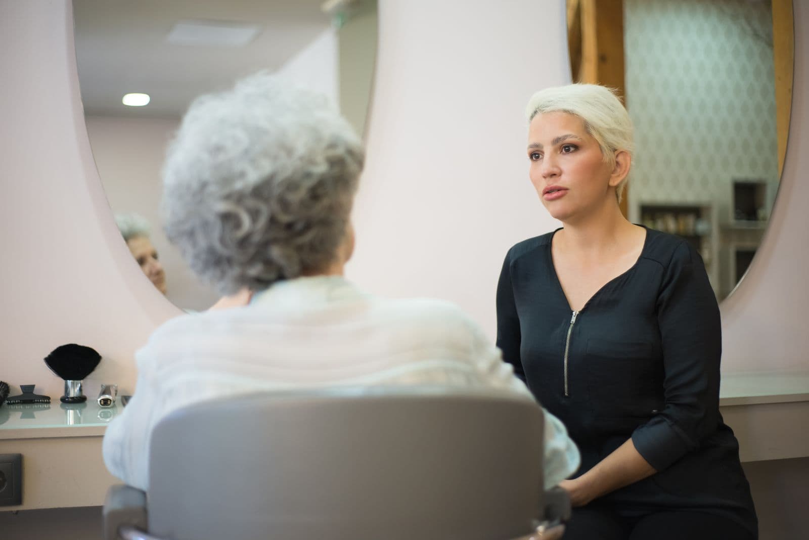 Illustrative Pexels stock photo of a stylist talking with a client in a salon; not Mosaic staff, a client, service, or endorsement