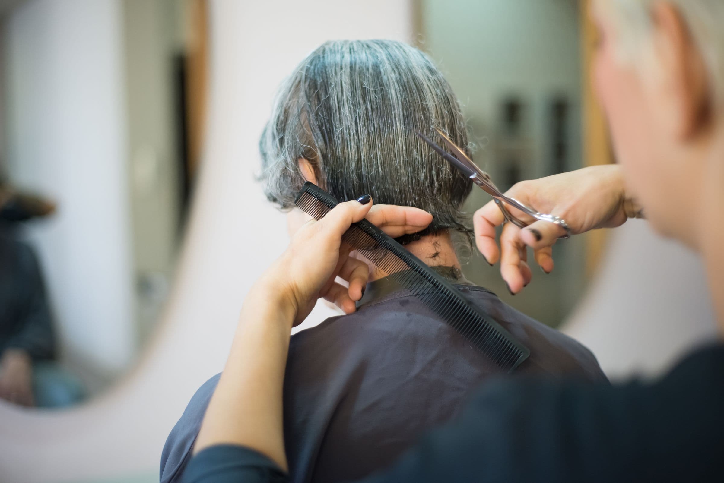 Illustrative stock photo of a stylist cutting a client's hair in a salon