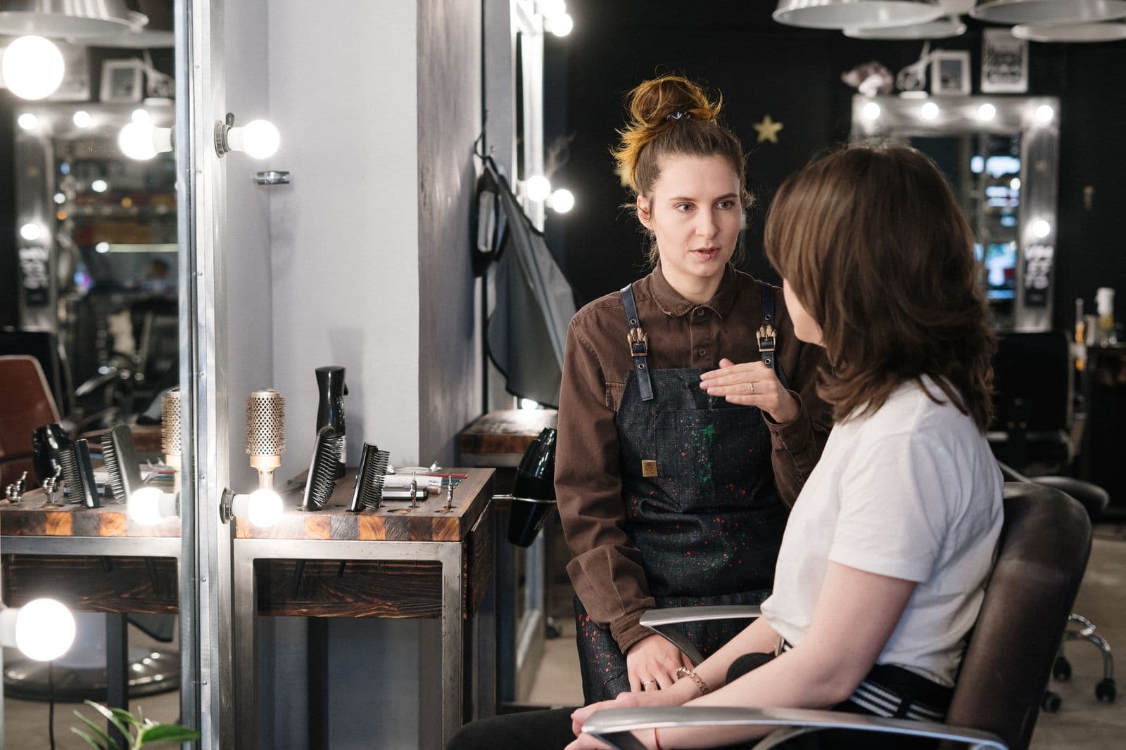Illustrative Pexels stock photo of a client speaking with a hairstylist in a salon; not a perm service, Mosaic staff, client, or result