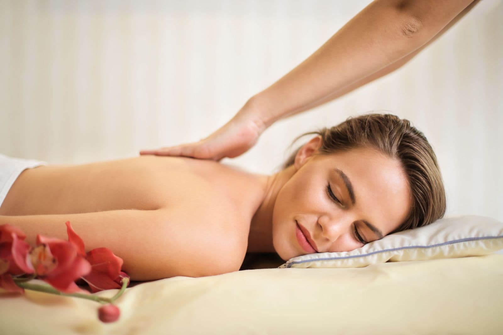 Illustrative stock photo of a woman resting on a massage table while receiving a back massage