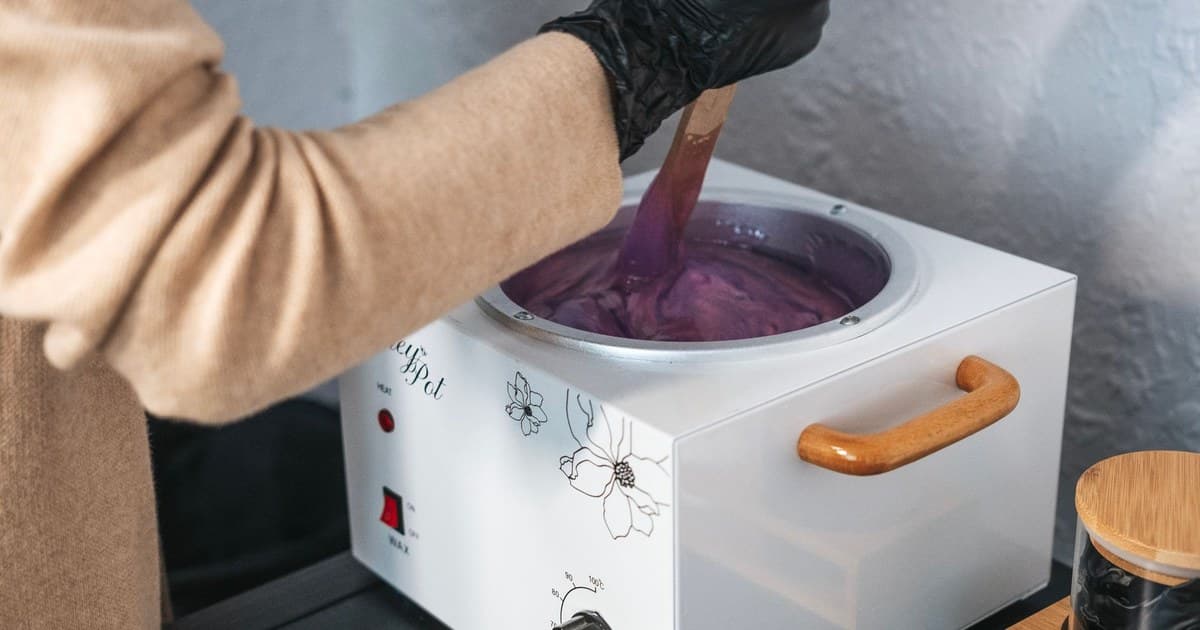 Professional esthetician preparing wax for a hair removal treatment